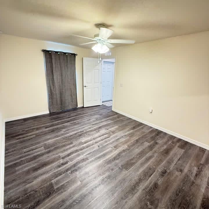 Unfurnished bedroom featuring ceiling fan and dark wood finished floors