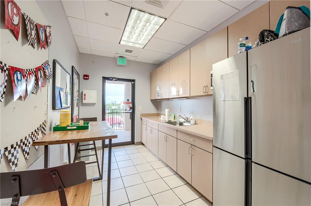 Kitchen with freestanding refrigerator, light countertops, and a paneled ceiling