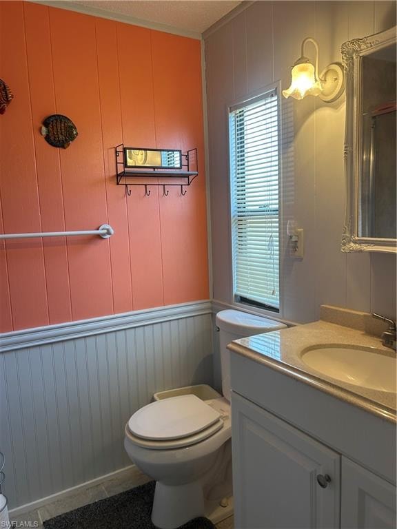 Bathroom featuring a decorative wall, wooden walls, and vanity