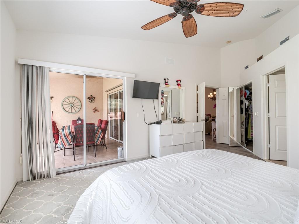 Bedroom featuring a chandelier, a closet, a ceiling fan, access to exterior, and vaulted ceiling
