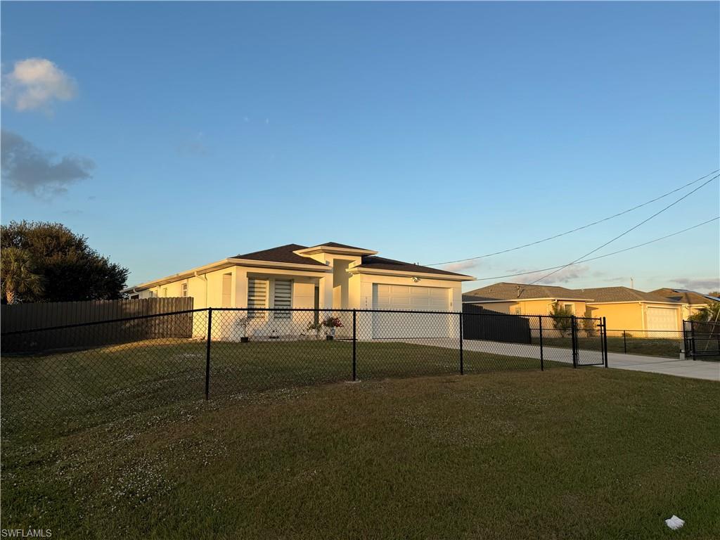 Rear view of house featuring stucco siding, an attached garage, and driveway