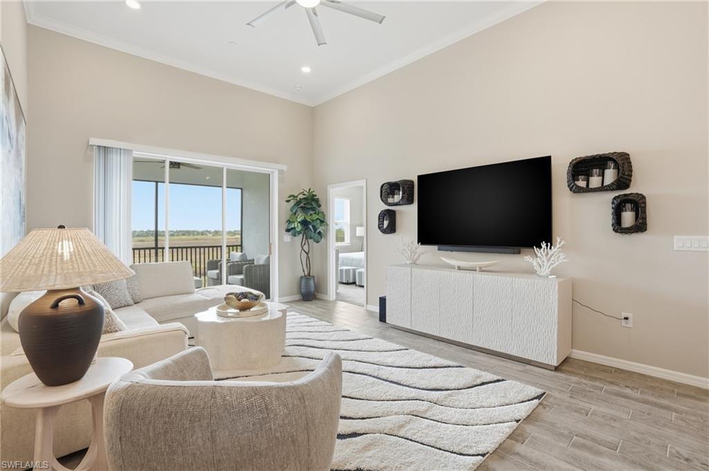 Living area featuring a ceiling fan, wood finish floors, and ornamental molding