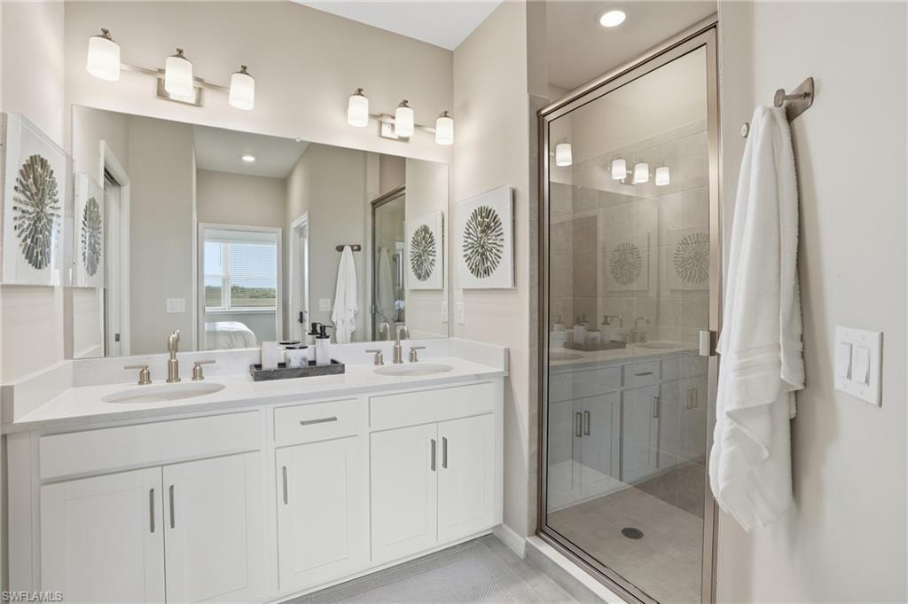 Bathroom featuring double vanity and a shower stall