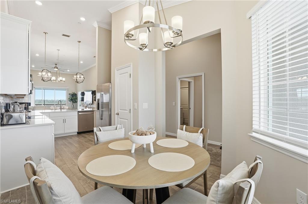Dining space featuring a chandelier, light wood-style floors, crown molding, and recessed lighting
