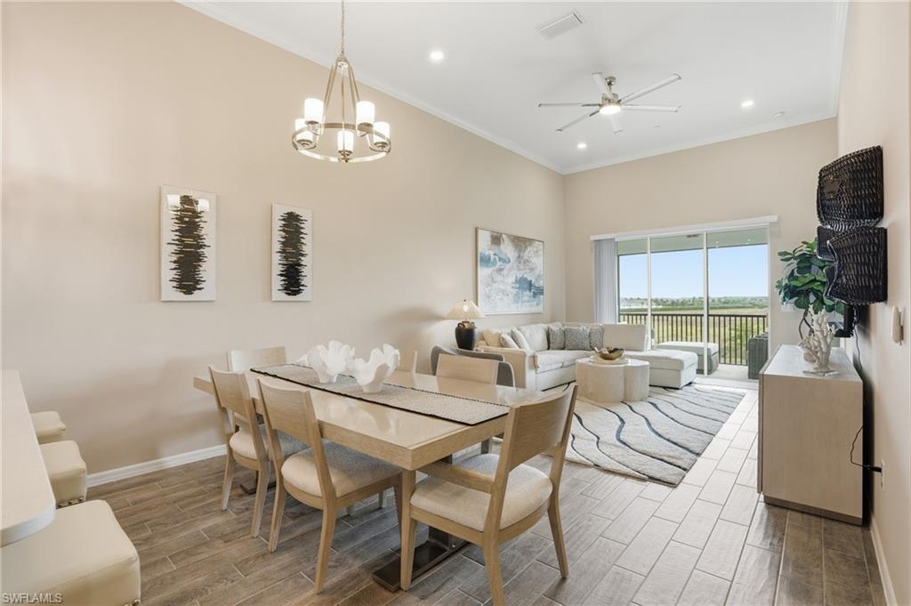Dining space featuring wood finish floors, crown molding, ceiling fan, a chandelier, and recessed lighting