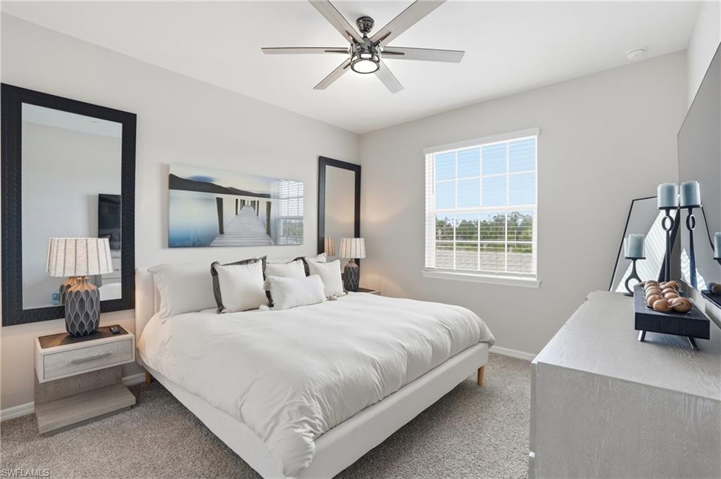 Carpeted bedroom featuring baseboards and a ceiling fan