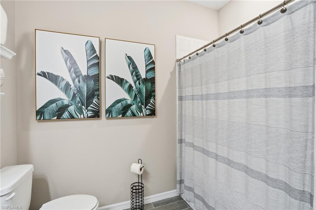 Full bathroom with a shower with shower curtain and toilet