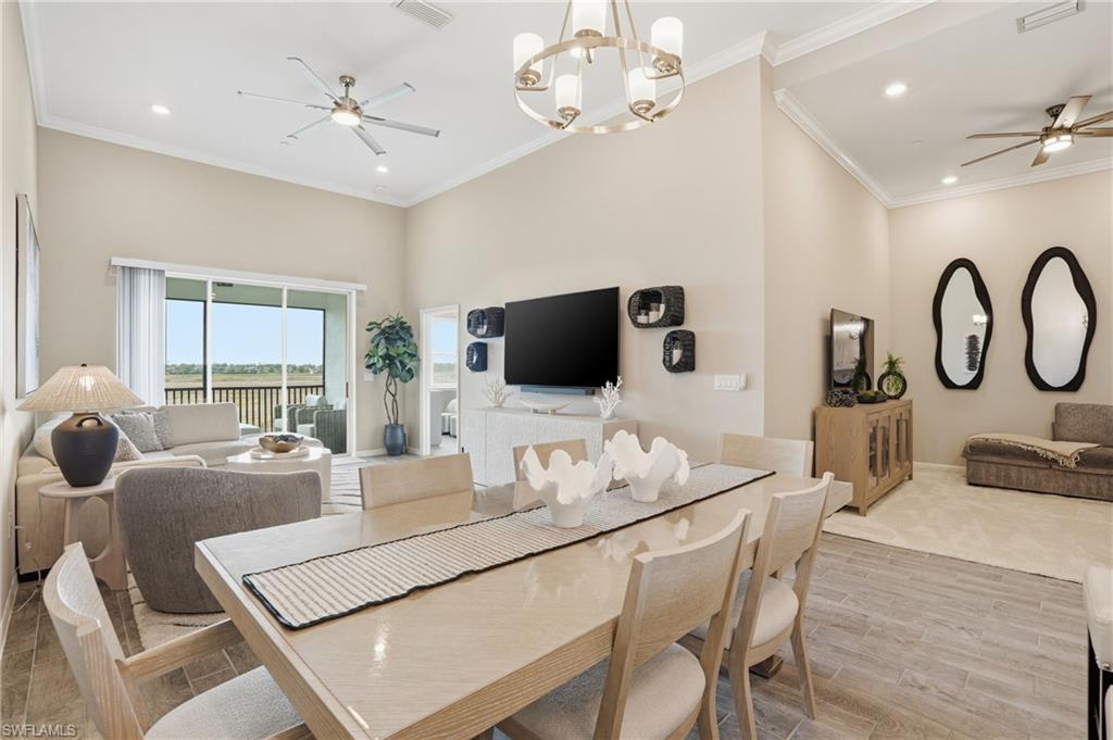 Dining area featuring ceiling fan, ornamental molding, recessed lighting, wood tiled floors, and a chandelier