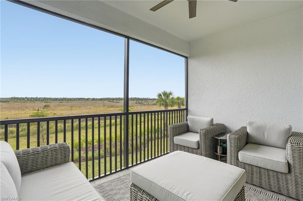 Sunroom / solarium featuring a ceiling fan, a balcony, a view of rural / pastoral area, and outdoor lounge area