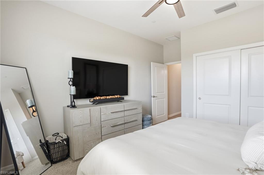 Bedroom with a closet, ceiling fan, and carpet floors