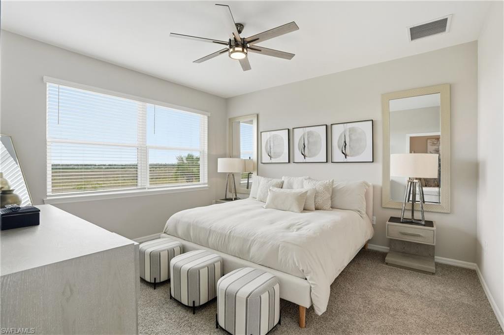 Carpeted bedroom featuring ceiling fan and baseboards