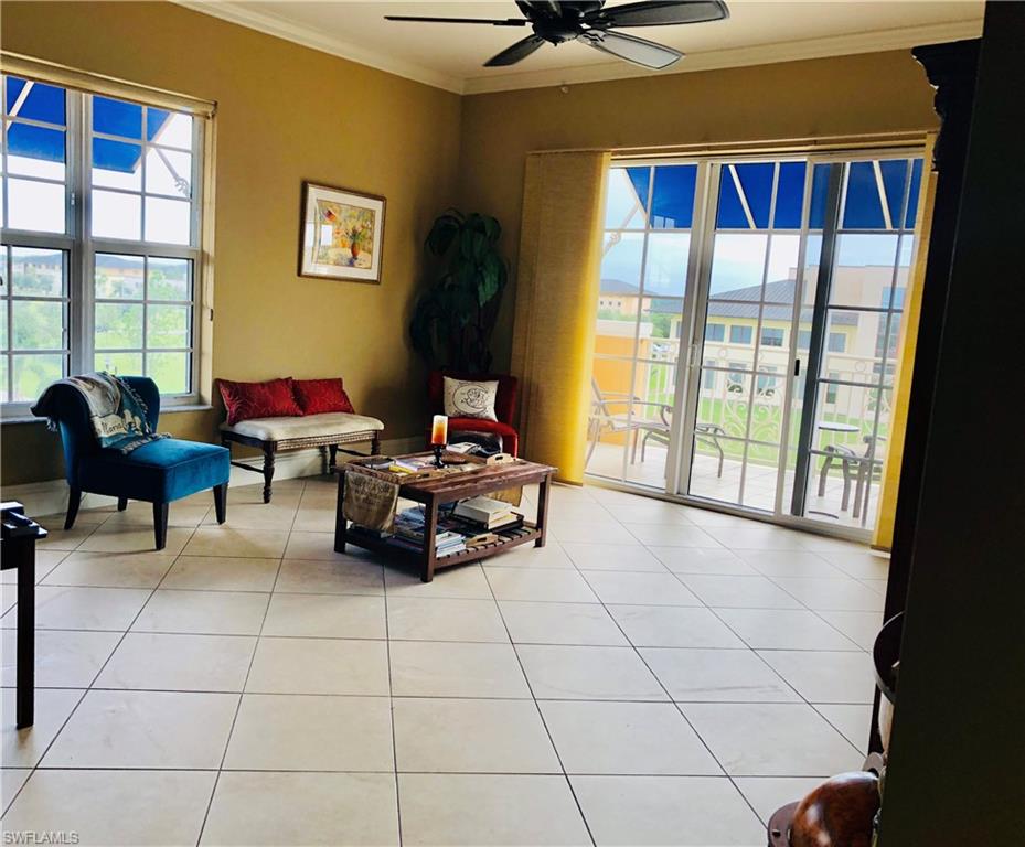 Living area with crown molding, light tile patterned floors, and ceiling fan