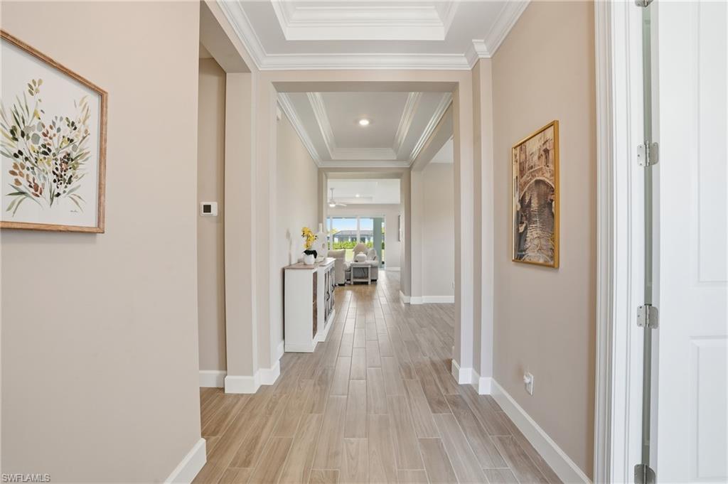 Hall featuring wood finish floors and a tray ceiling