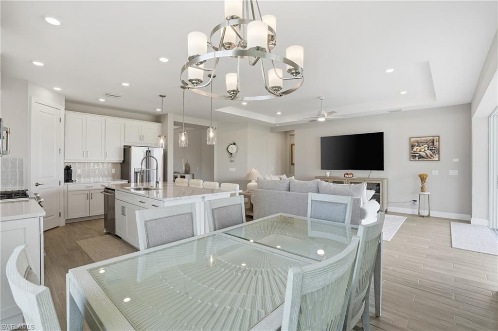 Dining space with recessed lighting, a chandelier, wood tiled floors, and ceiling fan