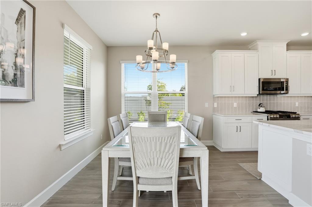 Dining space with wood tiled floors, recessed lighting, and a chandelier