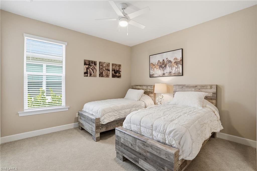 Carpeted bedroom featuring baseboards and a ceiling fan
