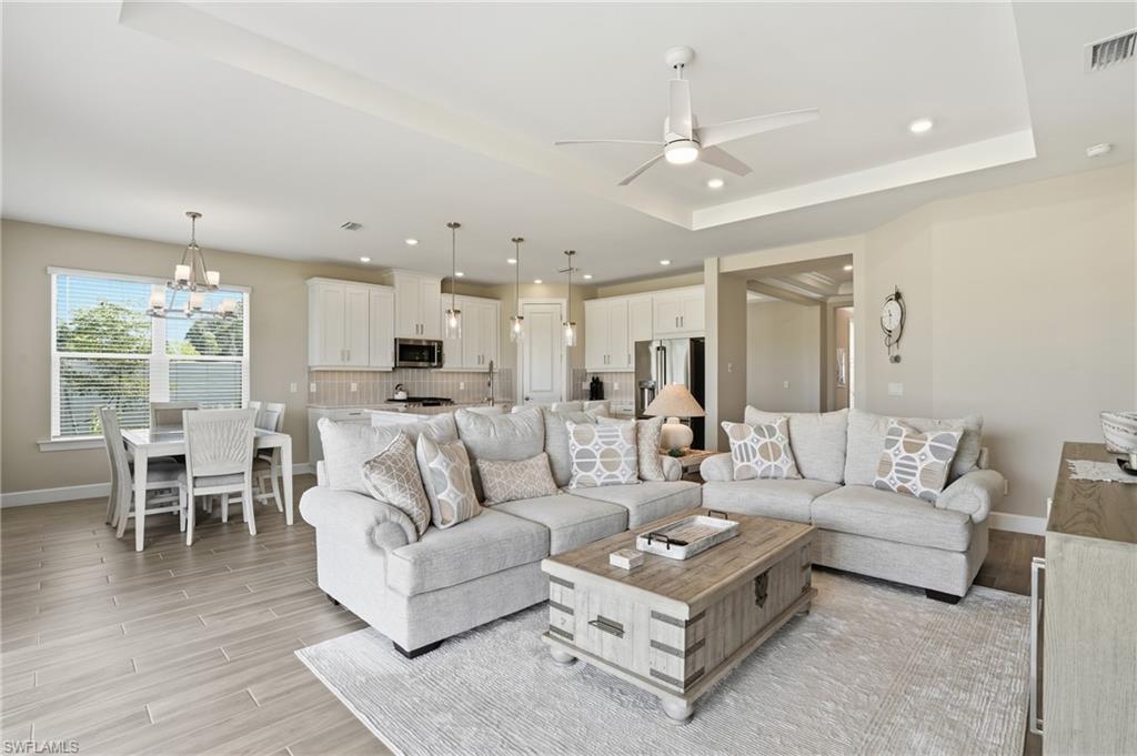 Living area with wood finish floors, recessed lighting, a chandelier, and ceiling fan