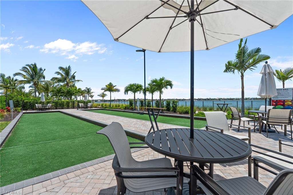 View of patio / terrace featuring a bocce ball area, a water view, and outdoor dining space
