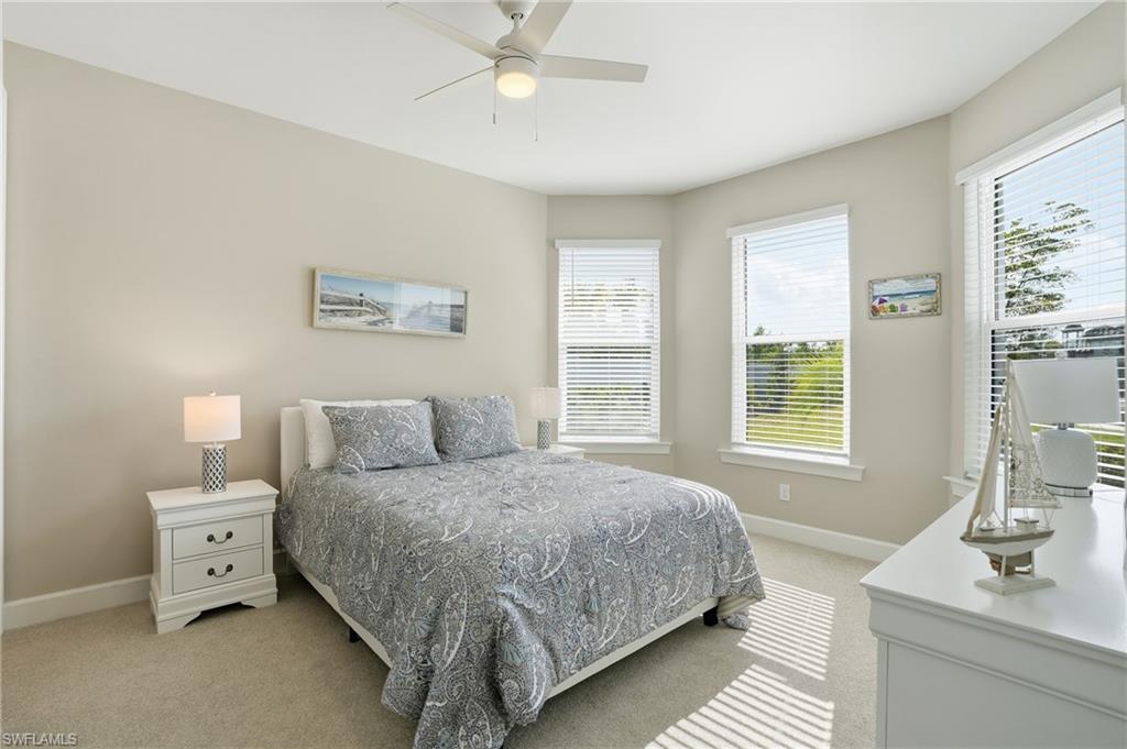 Bedroom with light carpet and a ceiling fan