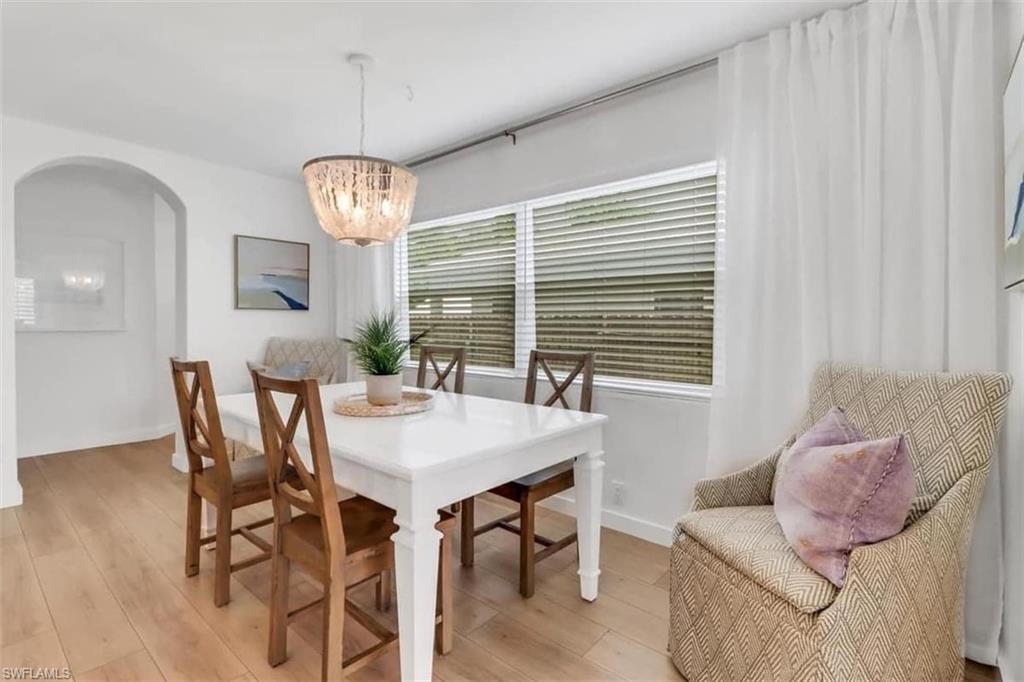 Dining space with light hardwood / wood-style floors and an inviting chandelier
