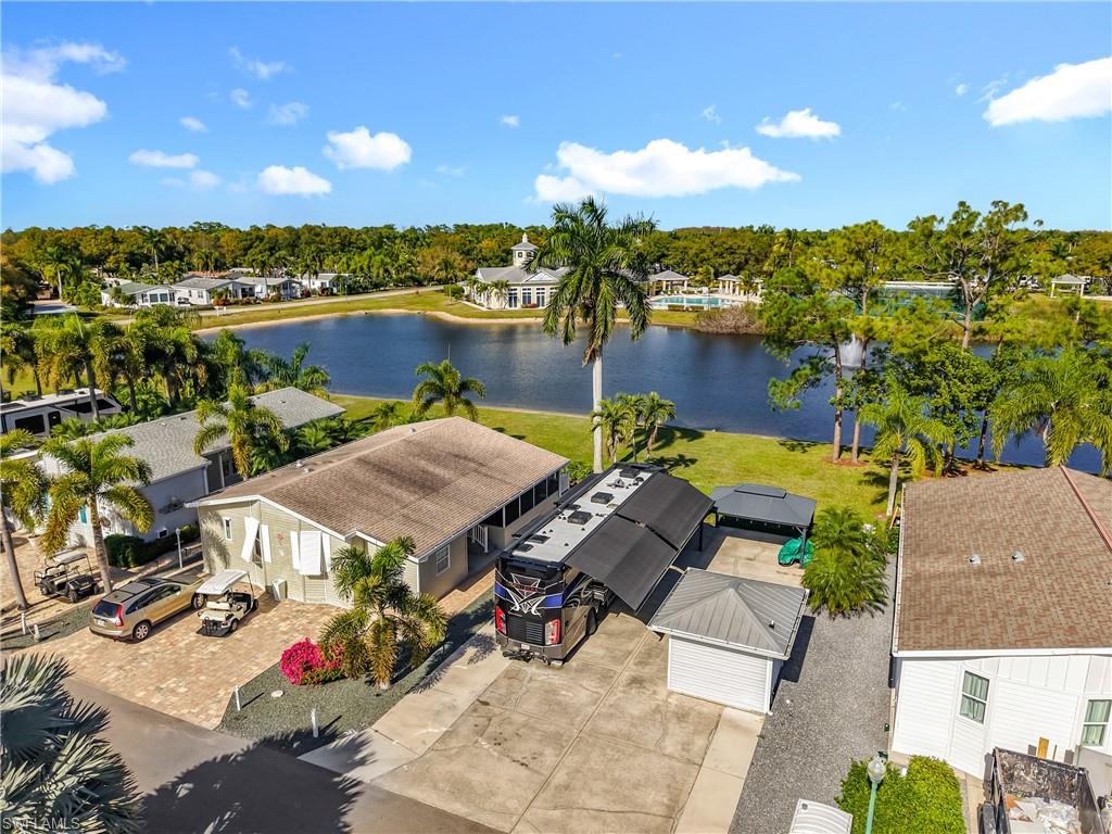 Aerial view of residential area featuring a large body of water and a tree filled landscape