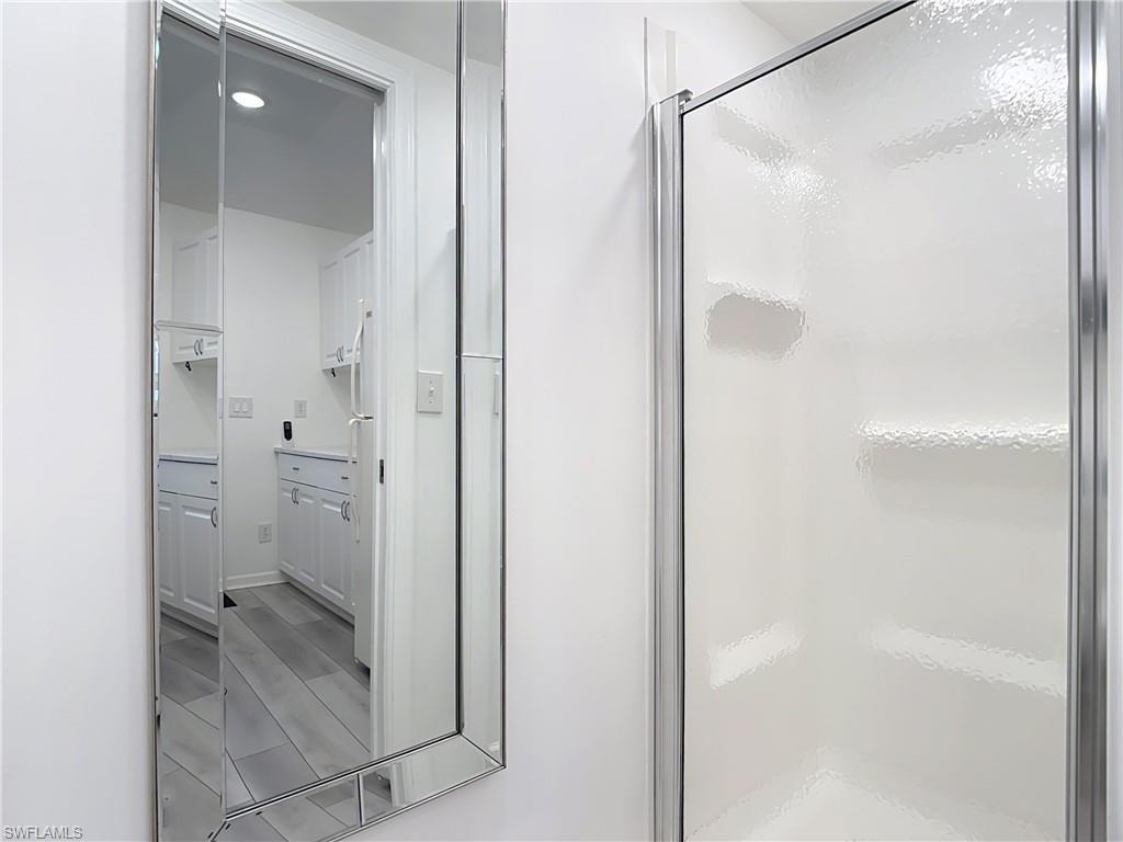 Bathroom featuring a stall shower and wood finish floors