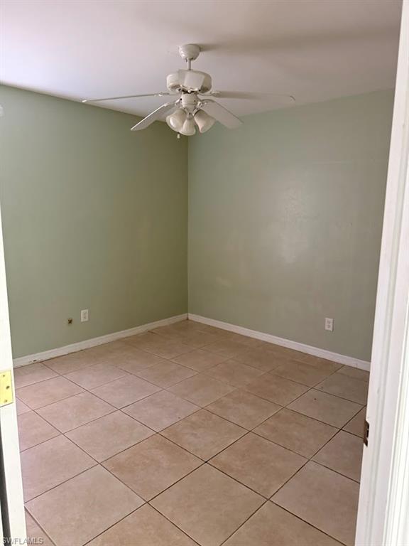Spare room with ceiling fan and light tile patterned floors