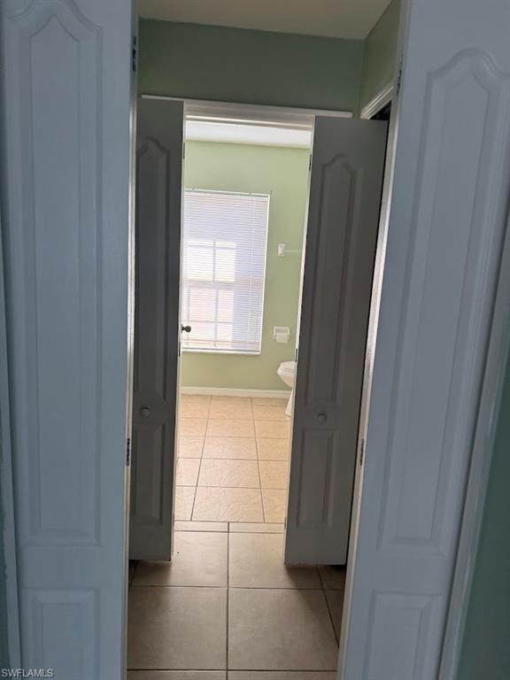 Corridor featuring tile patterned floors and baseboards