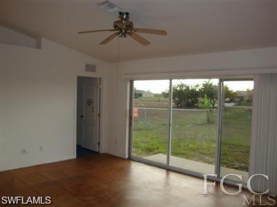 Empty room featuring lofted ceiling and a ceiling fan