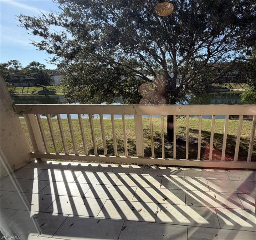 Wooden deck featuring a water view and a lawn