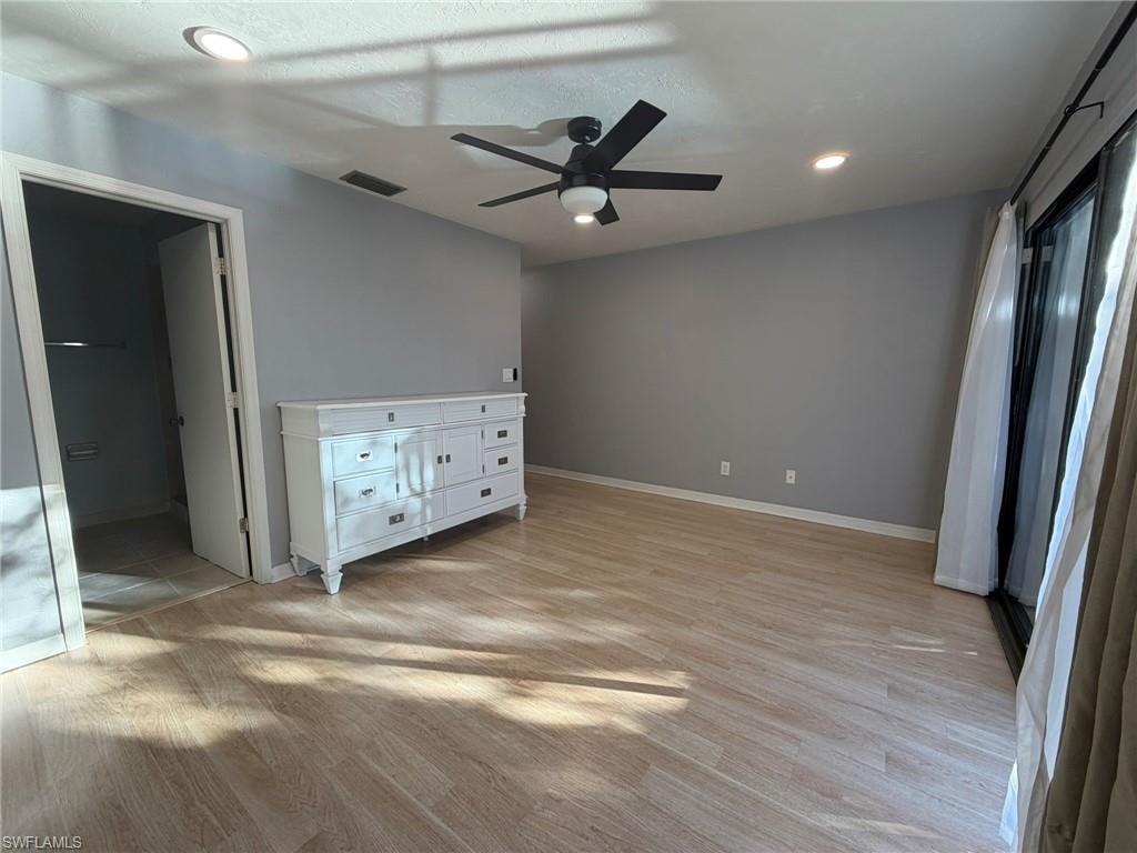 Unfurnished bedroom with light wood-style floors, a ceiling fan, recessed lighting, and ensuite bathroom
