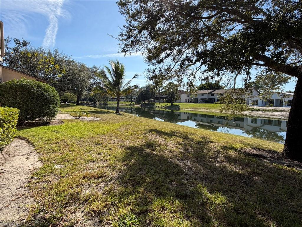 View of grassy yard featuring a water view and a residential view
