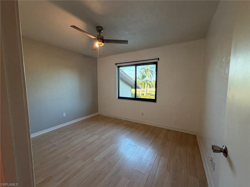 Empty room featuring light wood finished floors and a ceiling fan