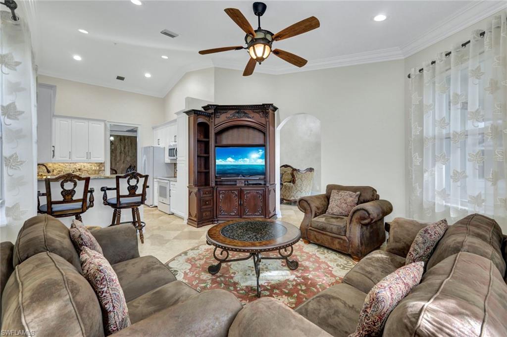 Living area featuring ornamental molding, ceiling fan, recessed lighting, and arched walkways