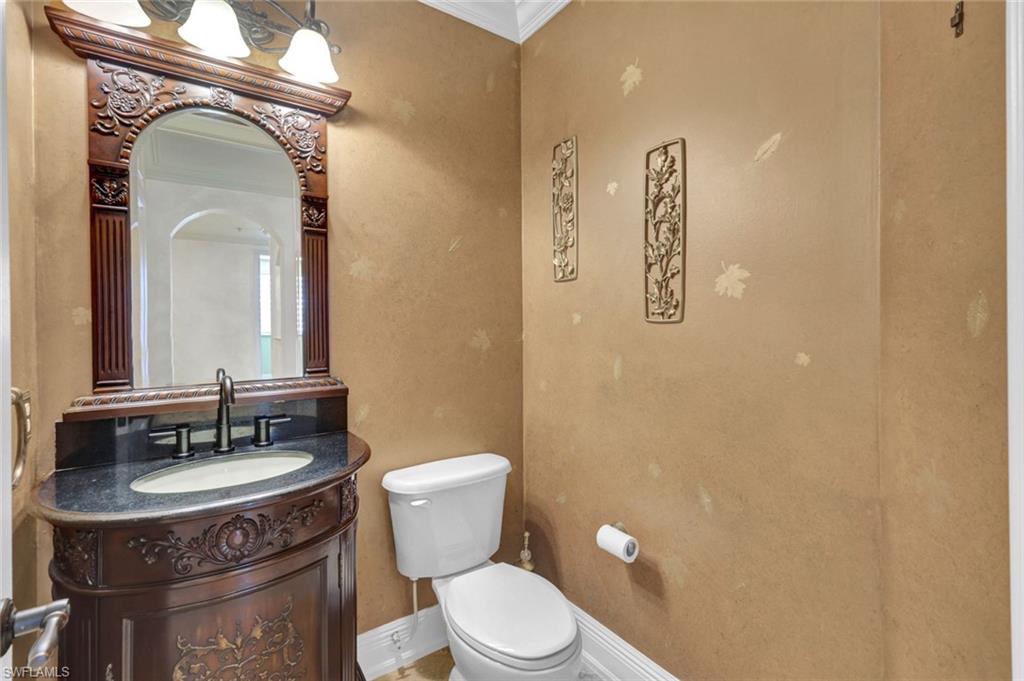 Half bathroom featuring vanity and ornamental molding
