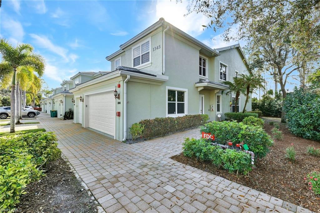 View of property exterior with stucco siding, decorative driveway, and a garage