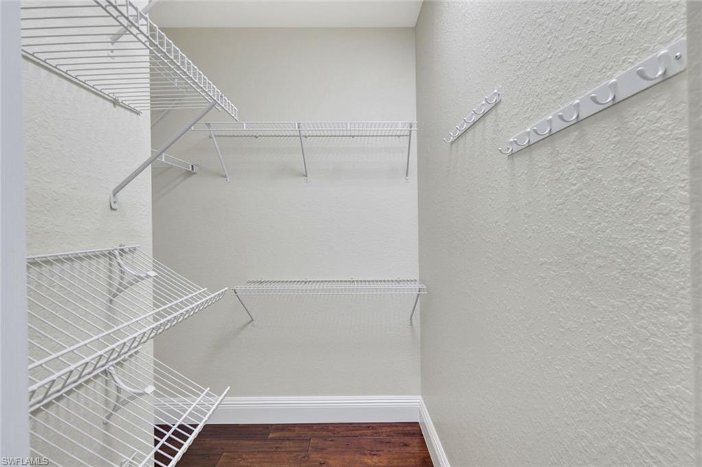 Walk in closet featuring dark wood finished floors