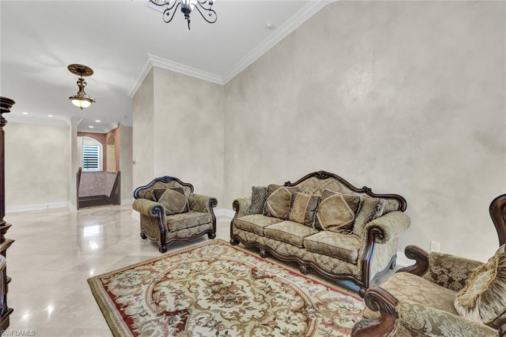 Living room with ornamental molding and a chandelier