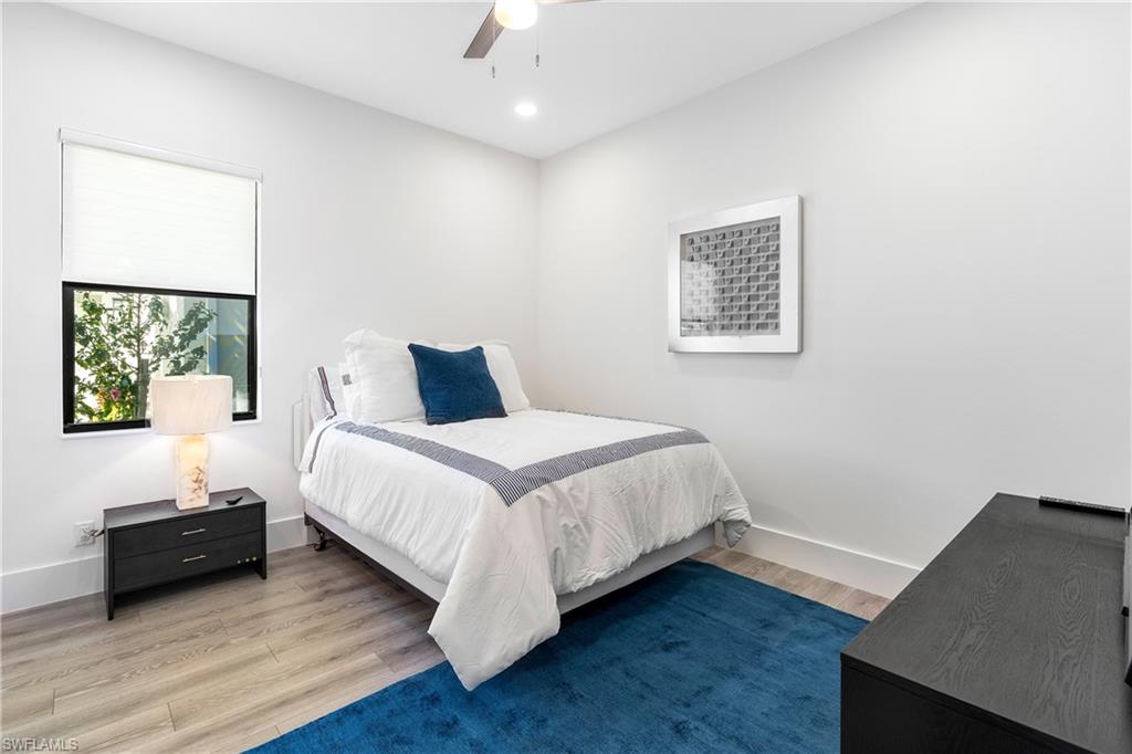 Bedroom with wood finished floors, ceiling fan, and recessed lighting