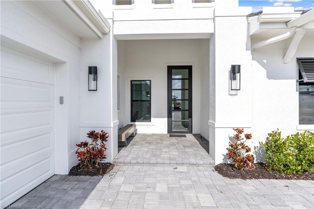 Doorway to property featuring stucco siding and a garage