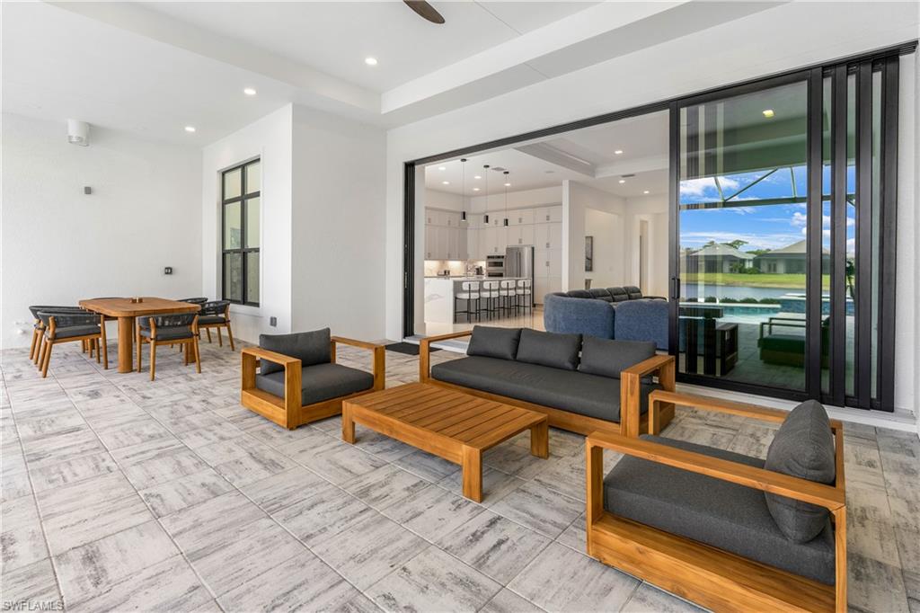 View of patio / terrace with ceiling fan, outdoor dining area, an outdoor hangout area, and a water view