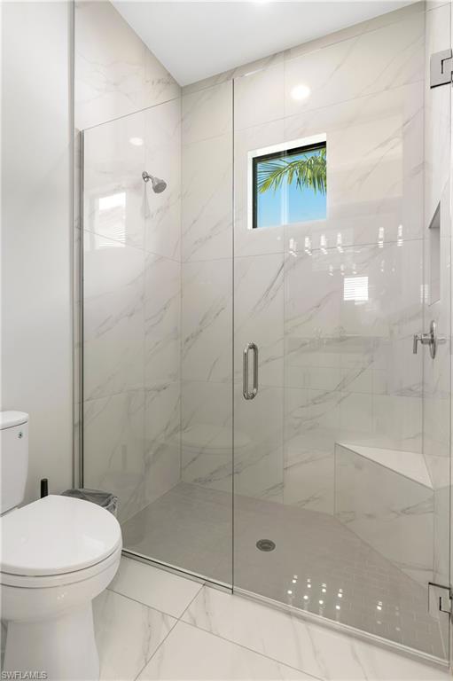 Full bathroom with a marble finish shower and marble finish flooring