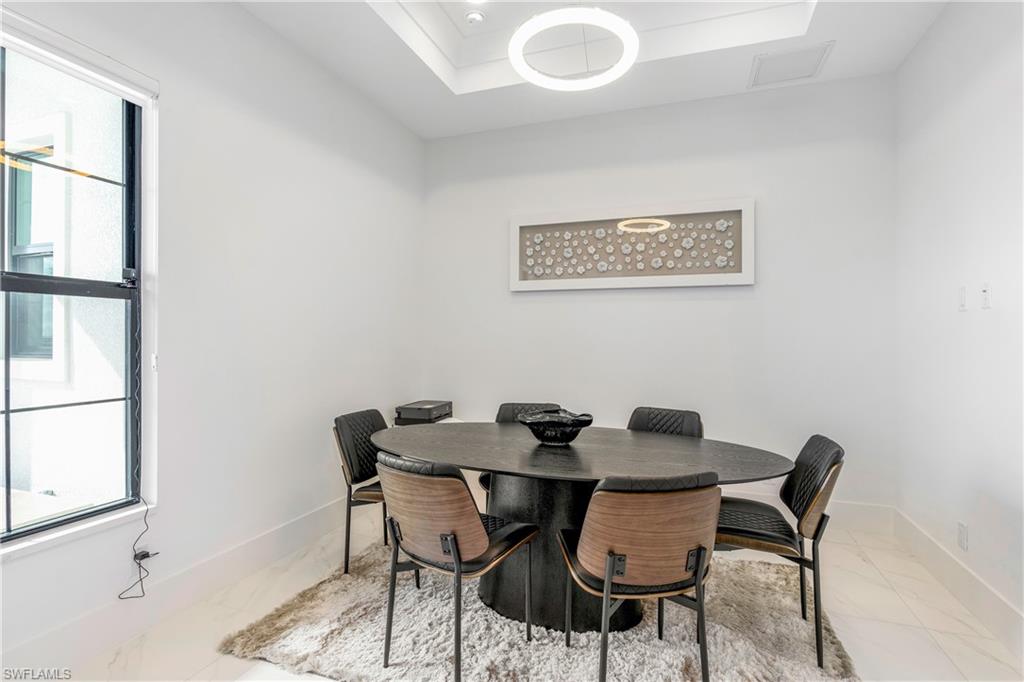 Dining space featuring a raised ceiling and baseboards