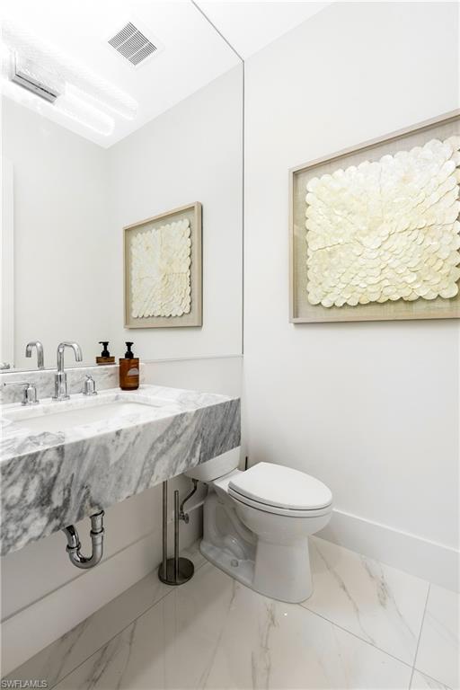 Bathroom featuring marble finish floors and baseboards
