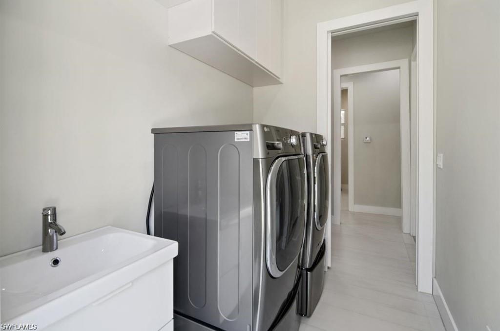 Washroom featuring separate washer and dryer and baseboards