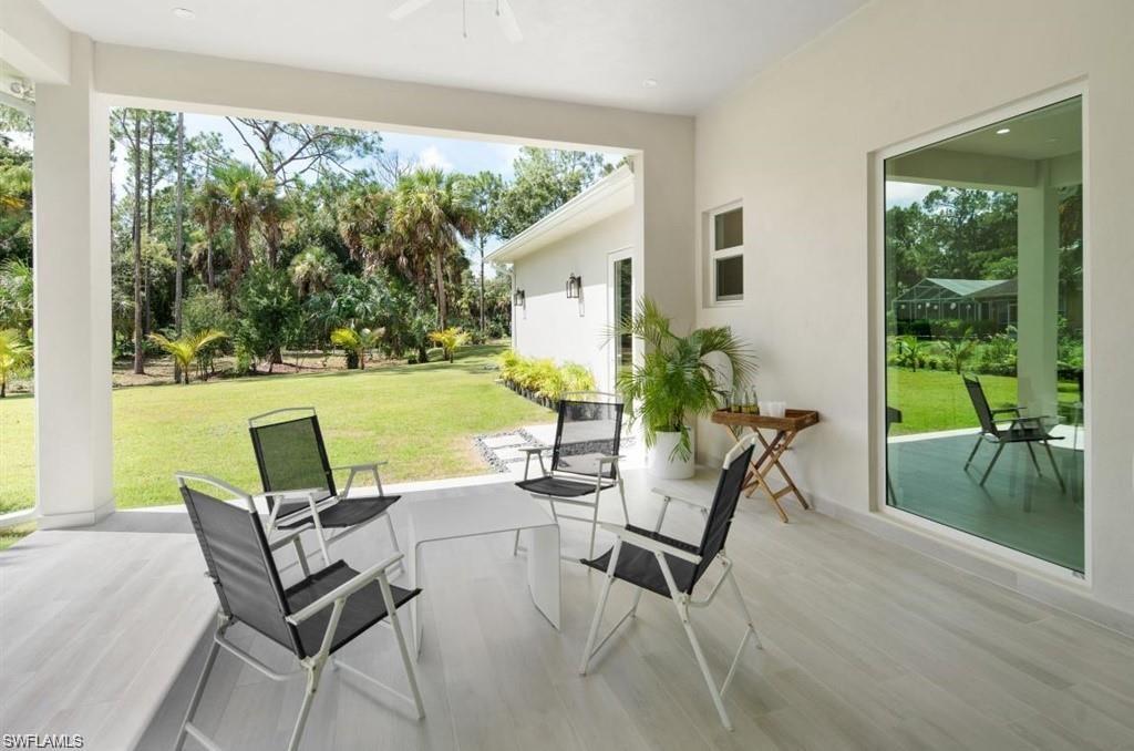 View of patio / terrace with a ceiling fan and view of wooded area