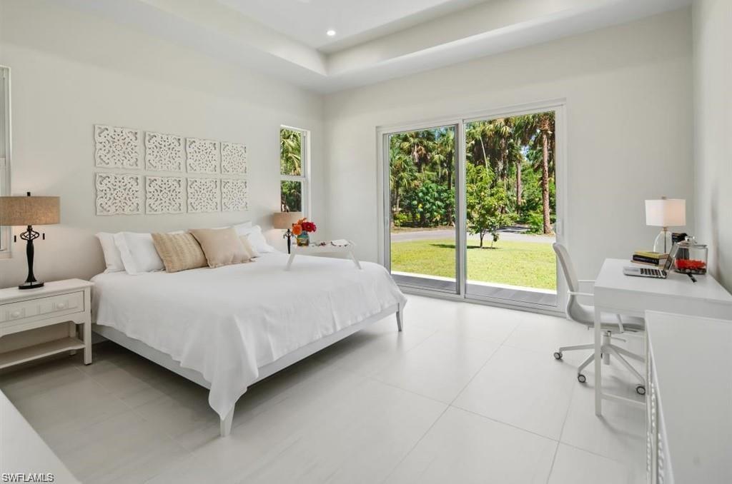 Bedroom featuring access to outside, recessed lighting, an office area, and a tray ceiling