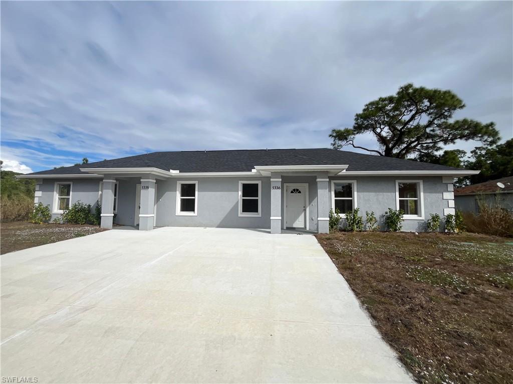 Single story home featuring stucco siding, driveway, and roof with shingles