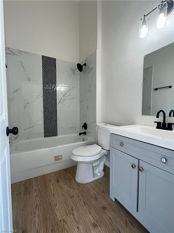 Full bathroom featuring vanity, shower / bathtub combination, and light wood-style floors