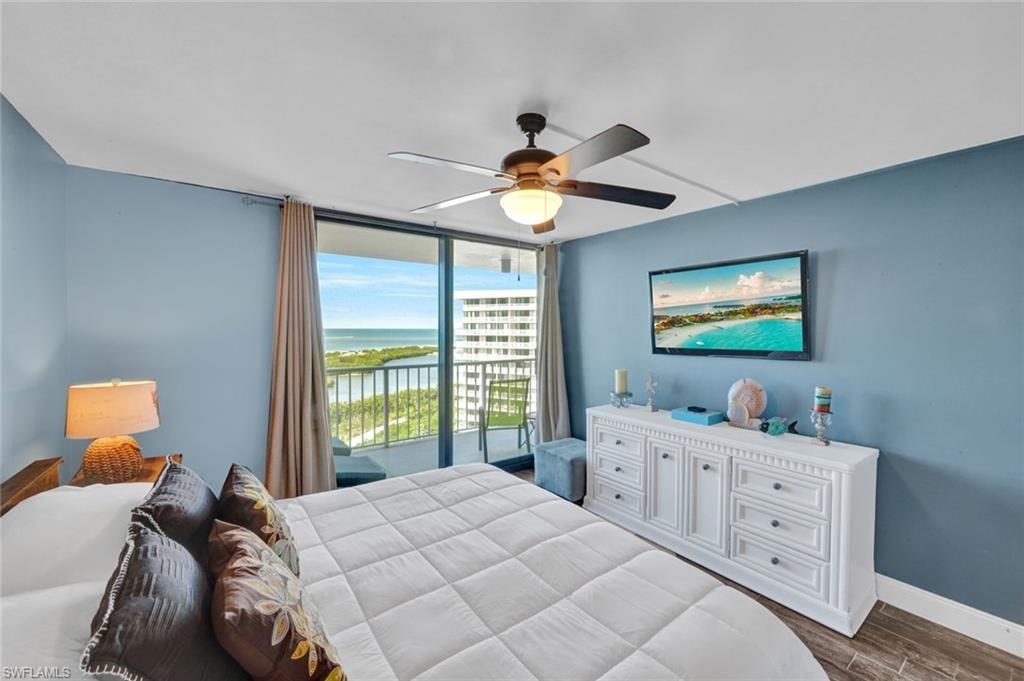 Bedroom with dark wood-style flooring, ceiling fan, and access to exterior